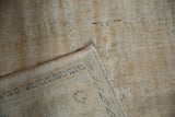 Underside of the distressed Oushak carpet showing its hand-knotted foundation and worn pile.