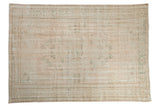 Distressed vintage Oushak rug, pale rose and ivory field with faded green floral pattern.