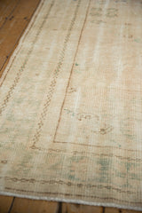 Textured vintage distressed Oushak rug with worn pale rose pile, visible foundation, and faint green motifs.