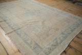 Worn pile and faded dusty blue arabesque border of a distressed vintage Oushak rug.