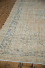 Distressed texture and faded dusty denim blue arabesque border on a vintage Oushak carpet.