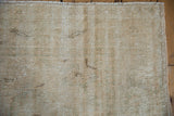 Distressed Oushak rug pile with muted cream, beige tones, and visible foundation.