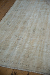 Worn cream foundation texture of the vintage distressed Oushak carpet with short fringe.