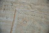 Distressed vintage Oushak rug with wear to foundation, cream pile, and secured selvage.