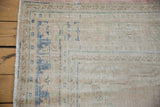 A corner view of the distressed Oushak carpet highlighting its worn texture and faded blue design.