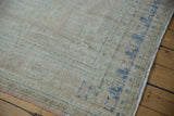 Distressed low-pile texture and visible knot heads on the corner of a vintage Oushak carpet.