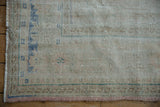 Detailed view of the low pile and visible knot heads on a distressed Oushak rug corner.