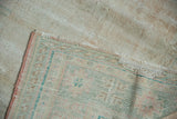 Back of the distressed Oushak carpet revealing the texture of its hand-knotted wool foundation.