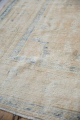Oushak carpet's distressed texture showing foundation, worn knot heads, and pale blue patterns.