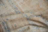 Close-up of vintage Oushak rug pile, showing distressed cream and faded blue texture.