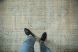 Vintage distressed Oushak rug showing worn pile, visible foundation, and soft neutral tones.
