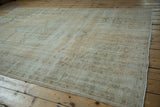 Distressed Oushak rug's worn texture showing exposed foundation, cream and pale coffee tones.