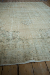 Distressed vintage Oushak carpet texture with visible foundation, wear, and faded cream and olive patterns.