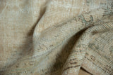 Distressed vintage Oushak carpet, showing worn pile texture in cream, brown, and pale olive.