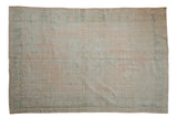 Distressed vintage Oushak carpet with faded peach, seafoam green, and muted medallion, 5'6