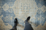 Distressed Vintage Sparta carpet with faded dusty blue and cream curvilinear pattern, showing worn pile.