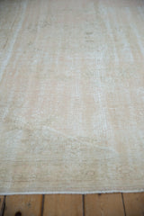 Distressed Oushak rug pile texture with foundation showing through pale beige and ivory.