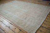 Distressed Oushak rug pile with mostly even wear, foundation visible, and pale pink-beige selvage.