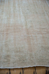 Distressed vintage Oushak rug pile texture, with exposed foundation in beige and pale pink.