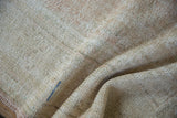 Distressed Oushak rug pile with mostly even wear, exposed foundation, and a blue stitch.