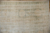 Distressed Oushak carpet pile detail with worn texture, muted ivory and sage tones.
