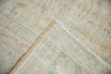 Distressed Oushak rug pile texture showing wear and restored side cord.