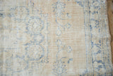 Distressed vintage Oushak rug with visible foundation, faded denim blue on cream.