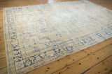 Distressed denim blue floral border and cream field of a vintage Oushak rug edge.