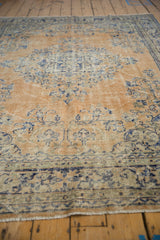 Distressed Oushak rug's apricot field with cobalt blue design and soft wear.