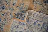 Distressed Oushak carpet pile in apricot, pale rust, cobalt blue, revealing hand-knotted reverse and selvage.