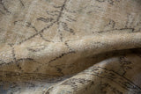 Distressed Oushak carpet pile showing worn botanical patterns in antique ivory and beige.