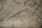Distressed vintage Oushak pile with exposed knot heads, woven foundation, and side selvage.