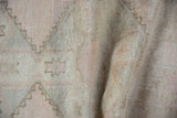Distressed Oushak runner texture highlighting lightning serrated contour and muted dusty rose geometric motifs.