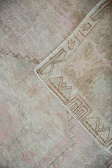 Distressed vintage Oushak rug corner, showing dusty rose pile and pale bronze reverse.