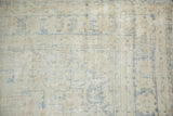 Distressed vintage Oushak carpet texture with visible foundation and soft blue lines.