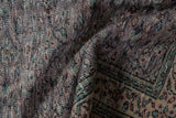 Distressed Vintage Oushak close-up, highlighting low pile, aubergine scrolling vines, and green border.