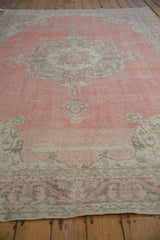 Distressed rose, ivory, and silver Sparta carpet with faint foundation showing through.