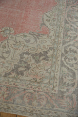Distressed vintage Sparta carpet corner with rose abrashed field, ivory spandrel, and fluid vine border.
