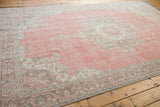 Distressed Sparta carpet corner with rose field, meandering vine, and palmette border.