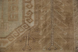Distressed vintage Oushak carpet showcasing beige geometric leaf border and faded tree of life motif.