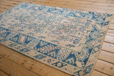 Distressed pink field with geometric vinery and indigo blue Safavid dragon style border.