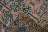 Distressed pink and blue pile, revealing the hand-knotted reverse of the vintage Melas rug.