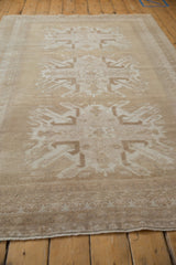 Distressed vintage Oushak carpet highlighting starburst floral motifs and pawn design border.