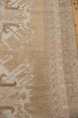 Distressed vintage Oushak carpet detail: even wear on soft beige, ivory pile, border with pawn motif.
