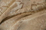 Distressed Oushak carpet pile showing worn beige and pale coffee brown texture.