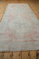 Distressed Oushak rug runner pile, showing rose, blush, ocean green tones and visible knot heads.