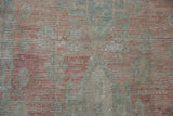 Distressed vintage Oushak rug pile with mostly even wear and rose, ocean green, ivory tones.