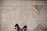 Distressed low-pile texture and geometric motifs on a vintage Oushak runner.