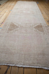 View down the length of a distressed Oushak runner highlighting its central geometric medallions.