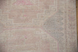Detail of the distressed Oushak's hand-knotted pile, showing even wear across the knot heads.